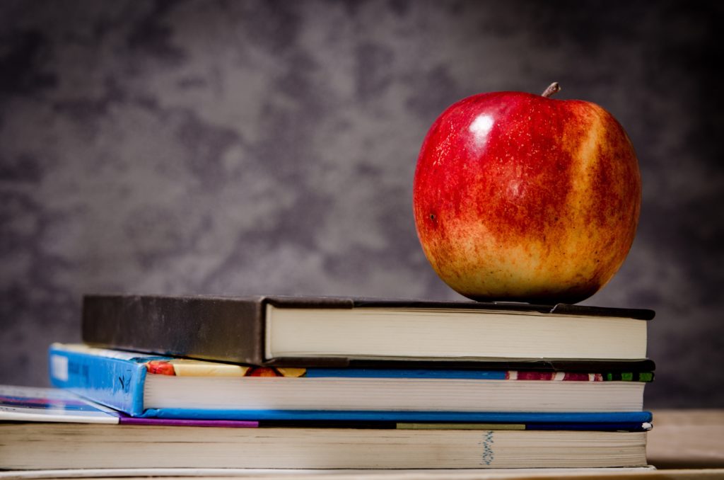 Boas vindas com uma maçã em cima de livros